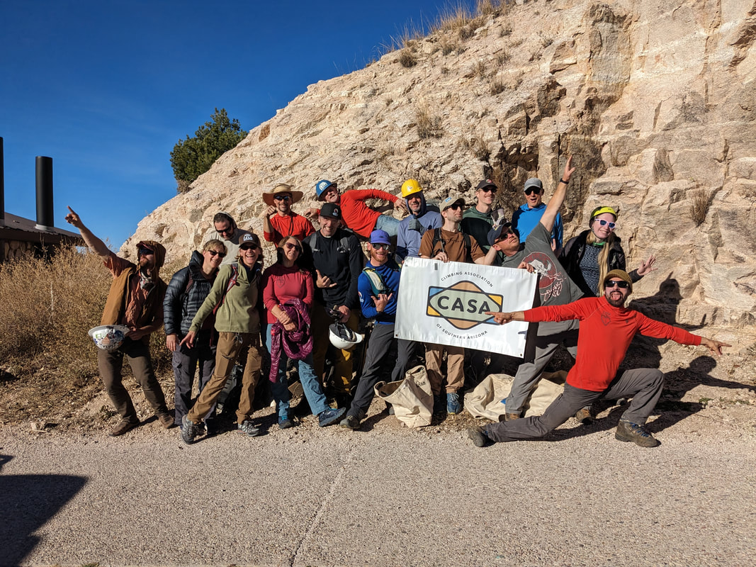 Group of stewardship volunteers posing with CASA banner at Windy Point